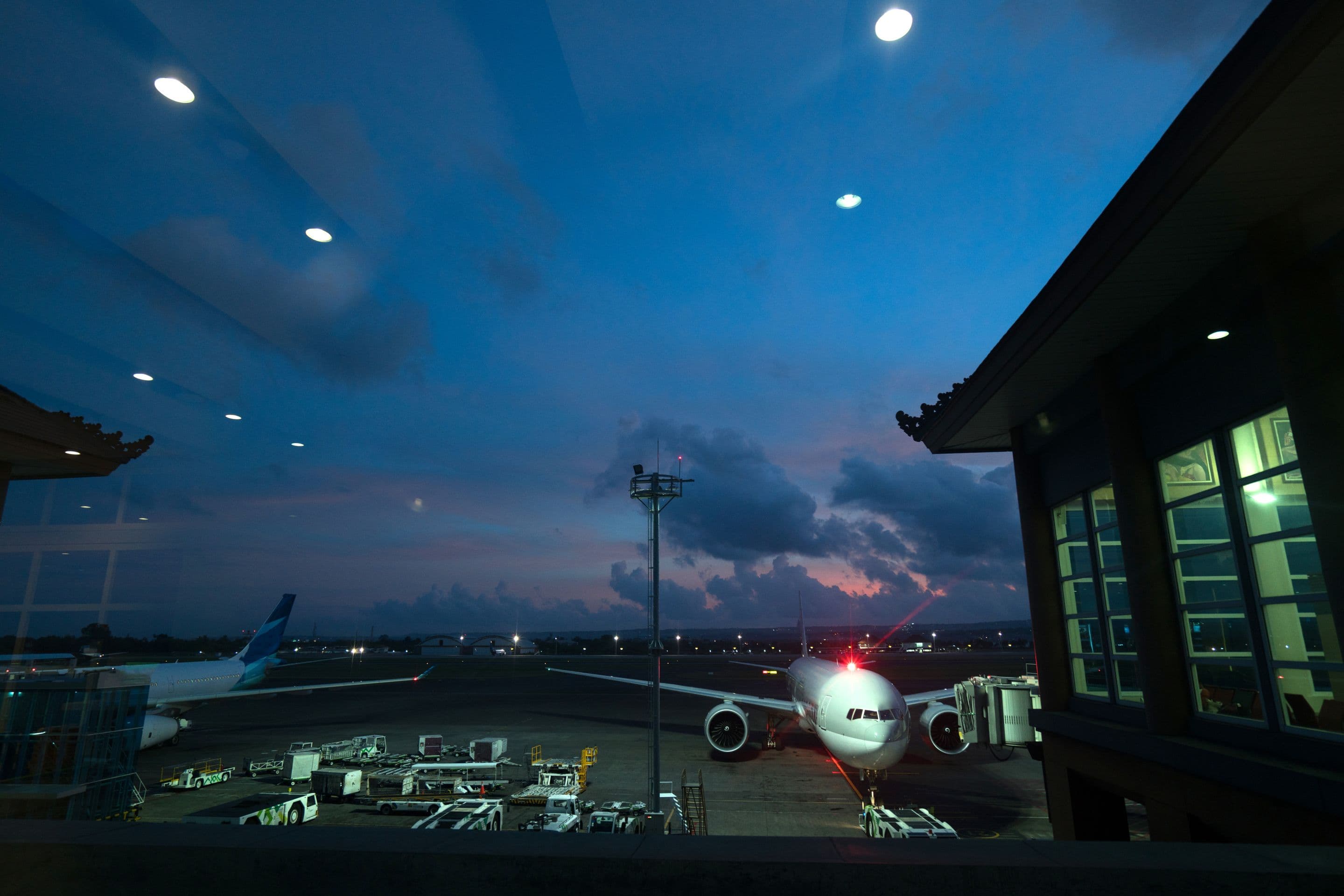 An airliner parked at a terminal gate at dusk